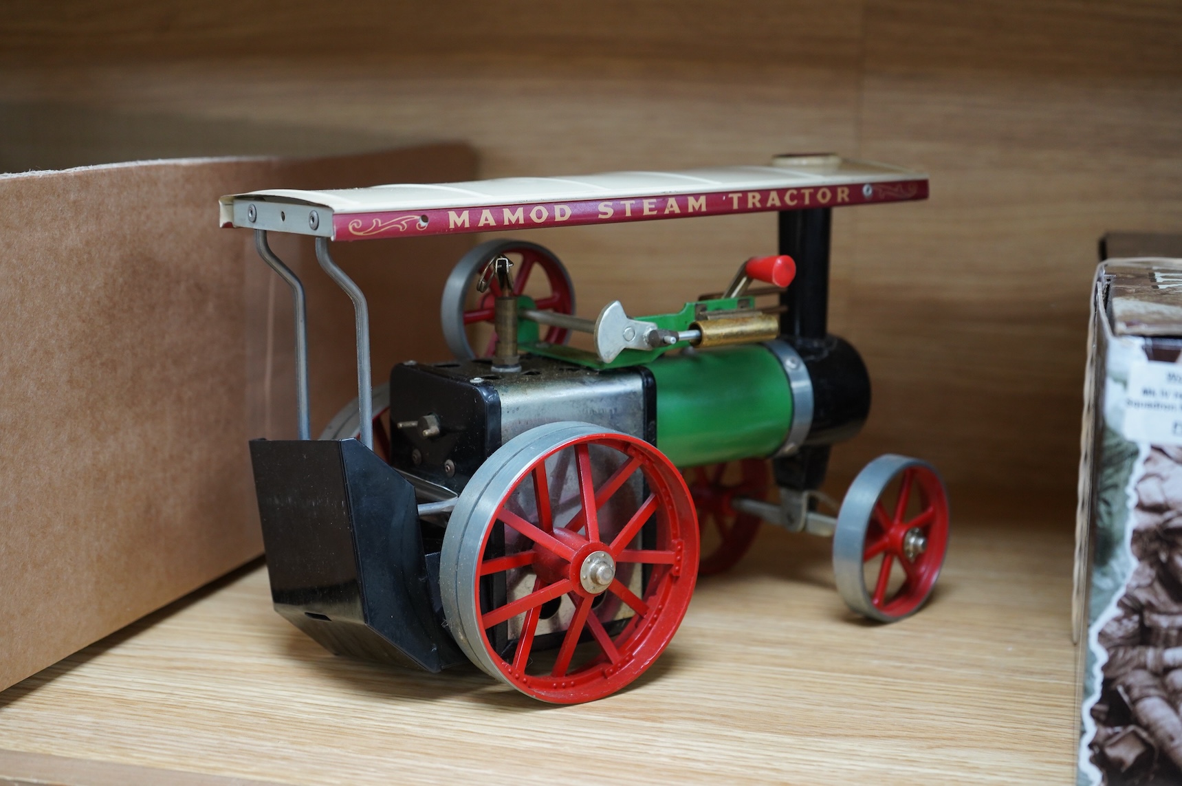 A boxed Mamod T.E.1a Steam Tractor, a boxed Britains 18” Howitzer field gun (2107), and a tinplate machine gunner (3)